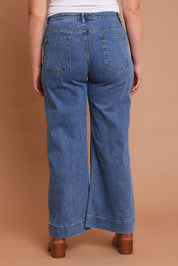 Model Chanel wearing size 16 of the Charlotte High Waisted Front Pocket Wide Leg Jean in colour Middenim (Blue), from the back