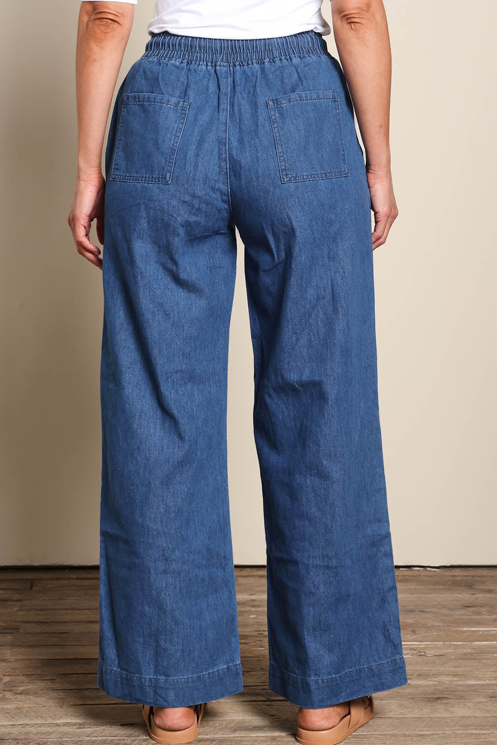 Model Riinar wearing size 10 of the Maya Wide Leg Drawstring Jean - Middenim in colour Middenim, from the back