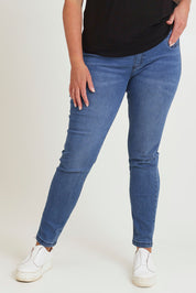 Model Chanel wearing size 16 of the Paige Pull On Jean in colour Midblue (Blue), from the front, cropped image