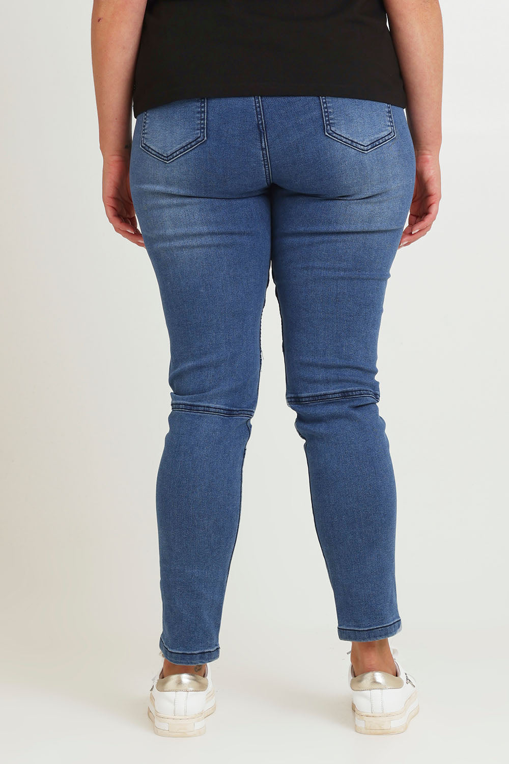 Model Chanel wearing size 16 of the River Ribbed Pull On Jean in colour Midblue (Blue), from the back