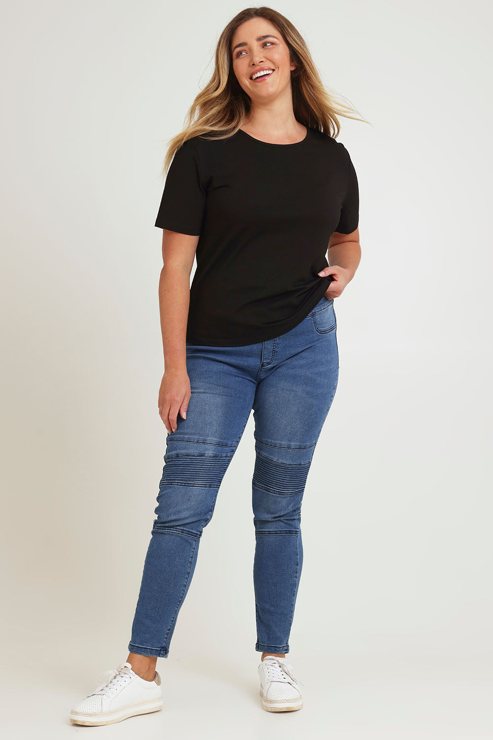 Model Chanel wearing size 16 of the River Ribbed Pull On Jean in colour Midblue (Blue), from the front, showing the whole outfit