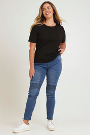 Model Chanel wearing size 16 of the River Ribbed Pull On Jean in colour Midblue (Blue), from the front, showing the whole outfit