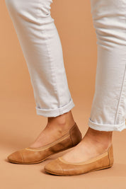 A model wearing size 38 of the Ava Leather Flat in colour Tan, from the front, cropped image