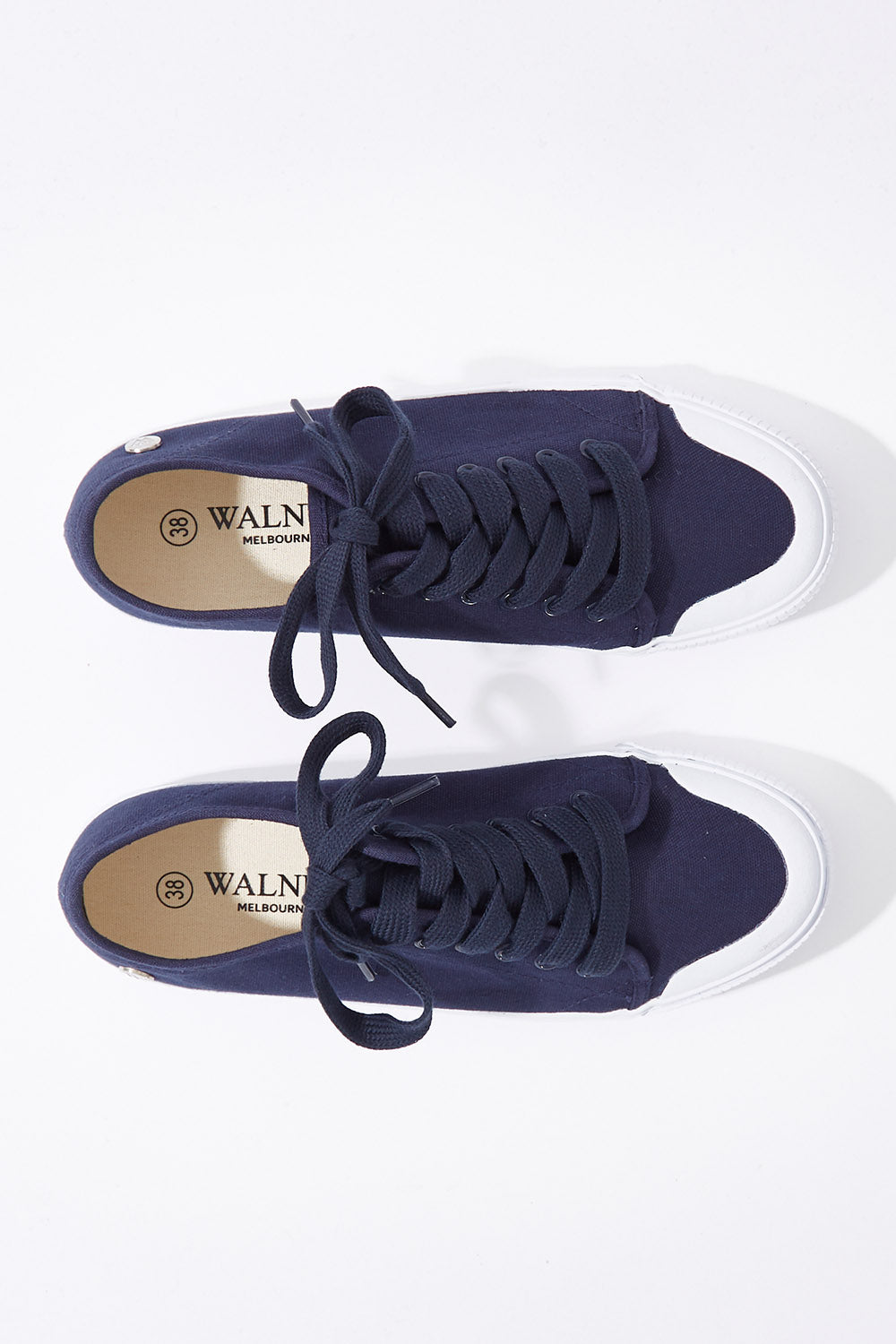 A model wearing size 37 of the Empire Canvas Sneaker in colour Navy (Blue), from the front, showing the whole outfit