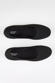 Model Genericm wearing size sample of the Eva Knit Ballet Flat - Black in colour Black, in a cropped view