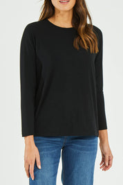 Model Madeline wearing size S of the Raglan Long Sleeve Tee in colour Black (Black), from the front, cropped image