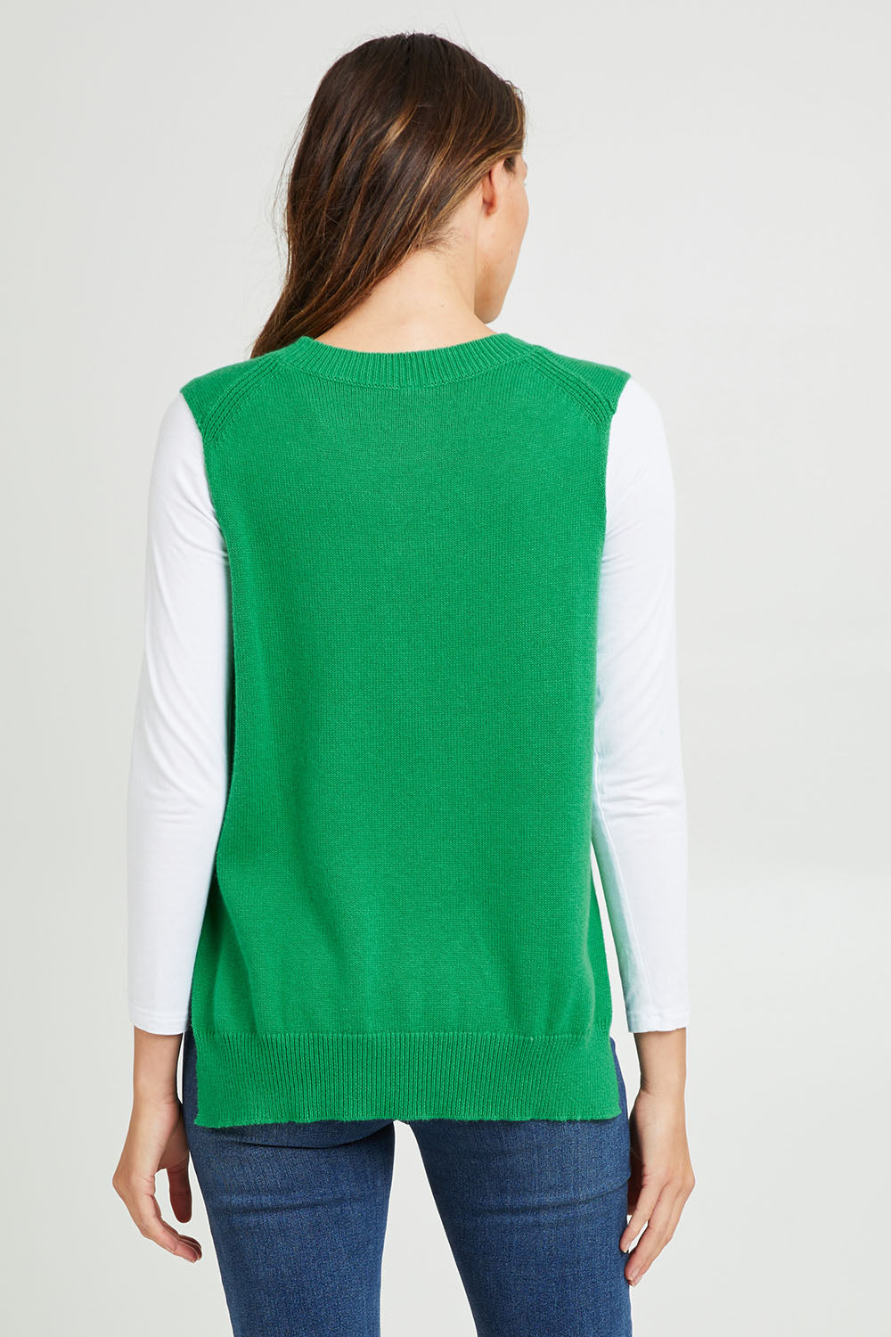 Model Madeline wearing size S of the Essential Vest in colour Emerald (Green), from the back