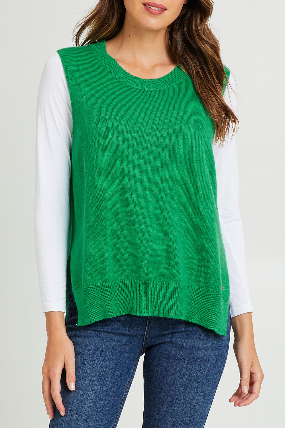 Model Madeline wearing size S of the Essential Vest in colour Emerald (Green), from the front, cropped image