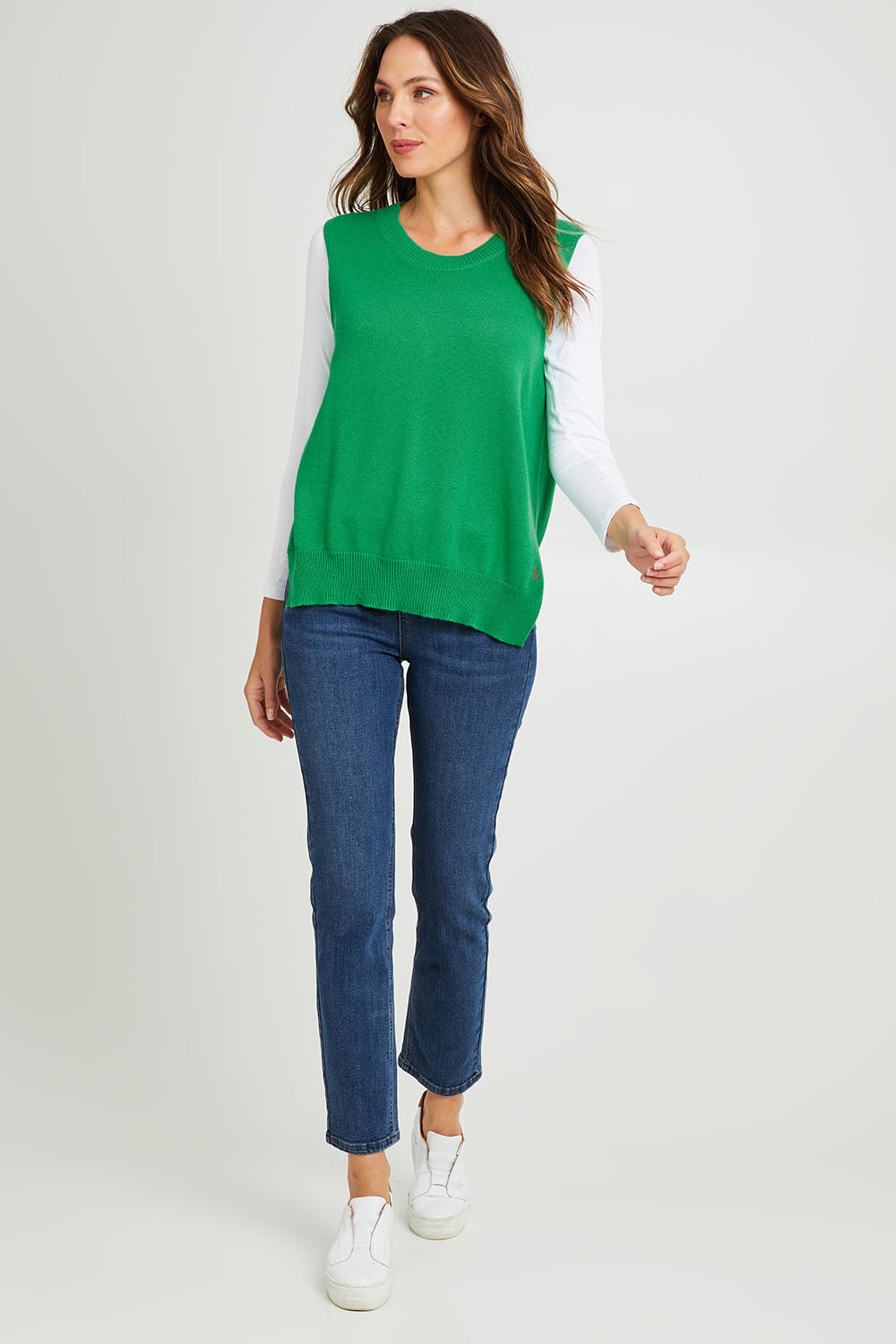 Model Madeline wearing size S of the Essential Vest in colour Emerald (Green), from the front, showing the whole outfit