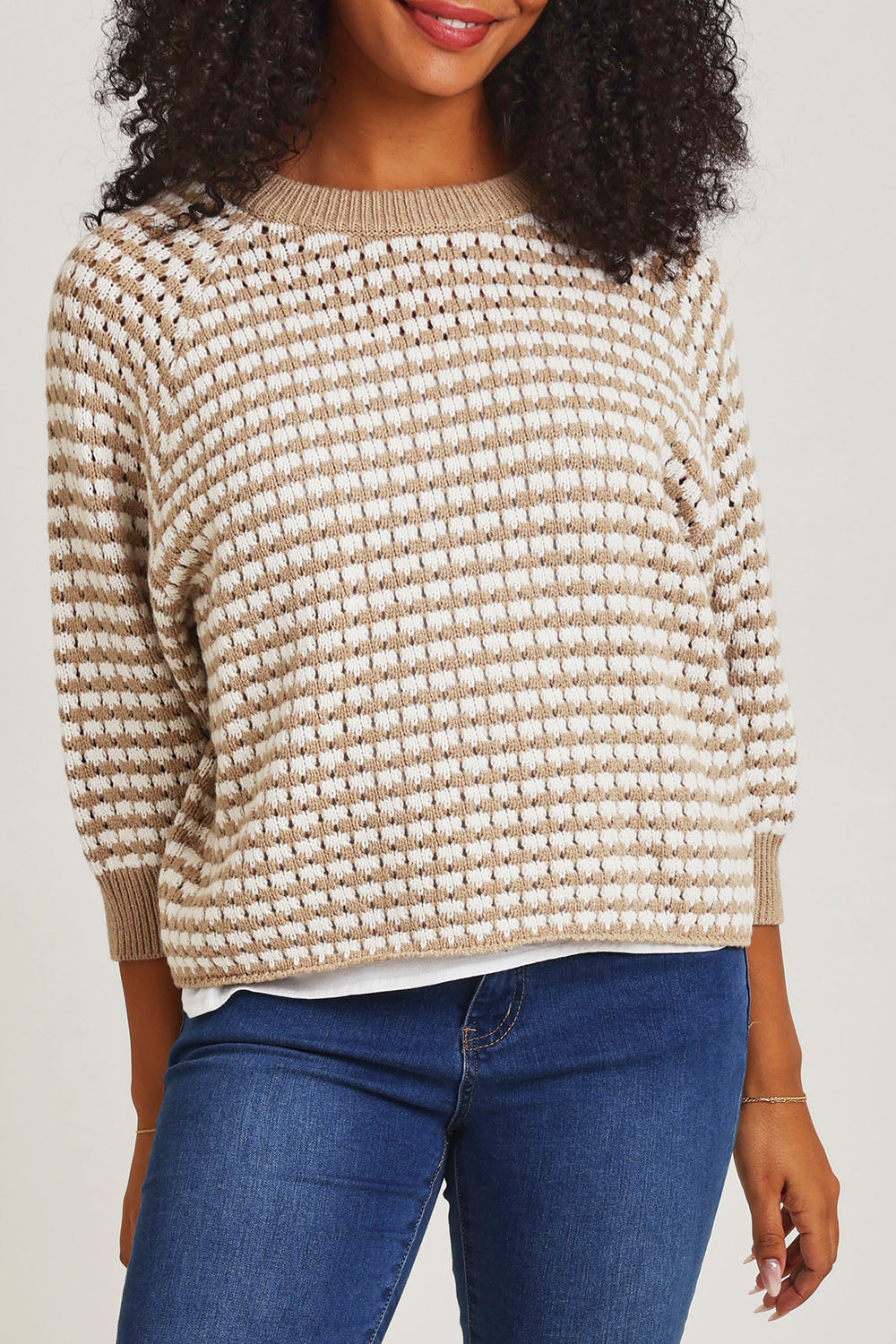 Model Ziara wearing size S of the Texture Cotton Merino Jumper in colour Camel, from the front, cropped image