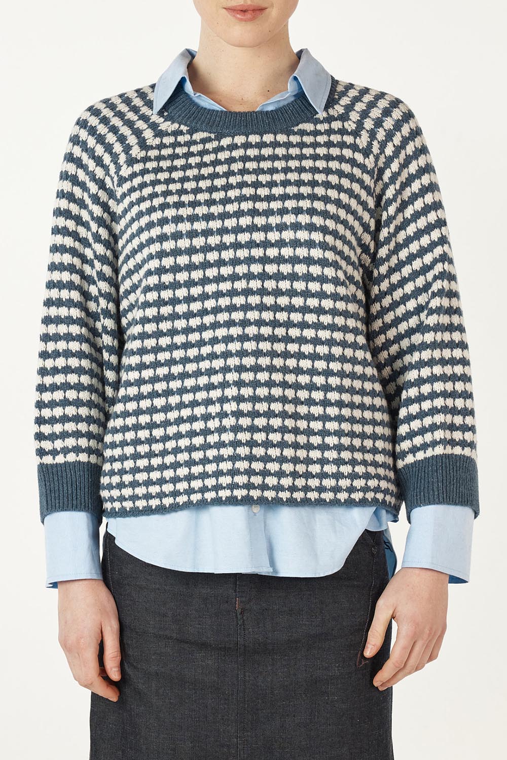 A model wearing the Texture Cotton Merino Jumper in colour Denim (Blue), from the front, cropped image