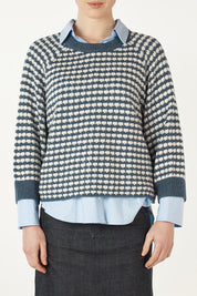 A model wearing the Texture Cotton Merino Jumper in colour Denim (Blue), from the front, cropped image
