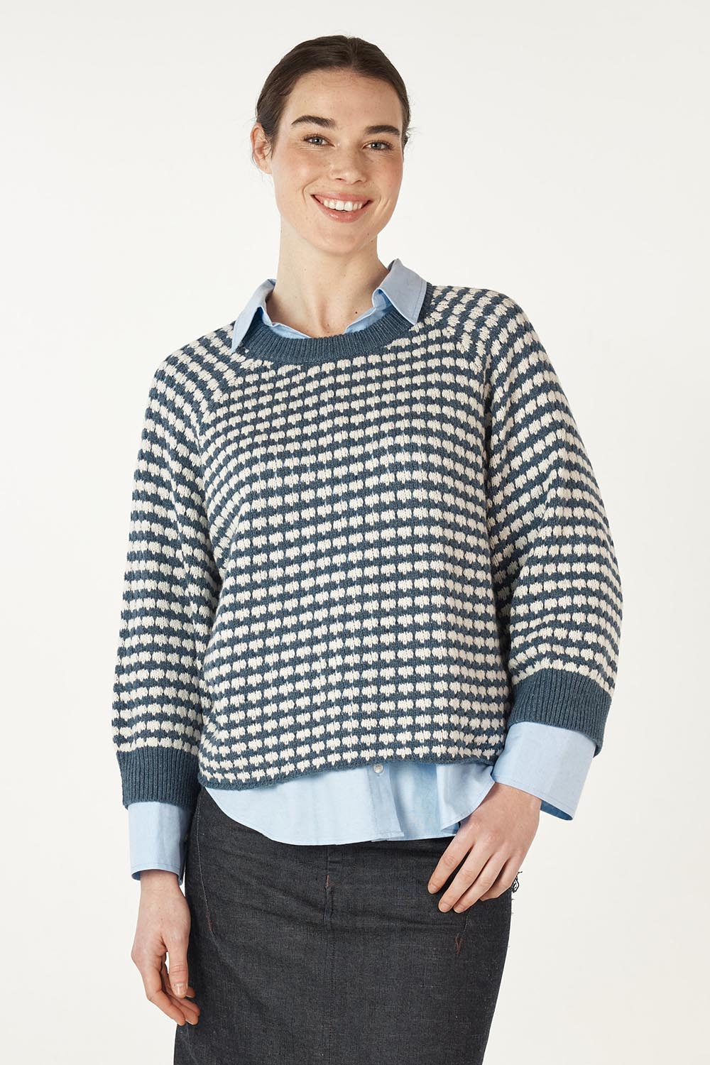 A model wearing the Texture Cotton Merino Jumper in colour Denim (Blue), from the front, cropped image