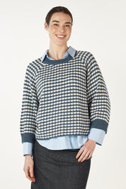 A model wearing the Texture Cotton Merino Jumper in colour Denim (Blue), from the front, cropped image