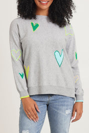Model Ziara wearing size S of the Intarsia Hearts Cotton Cashmere Jumper in colour Marl (Grey), from the front, cropped image